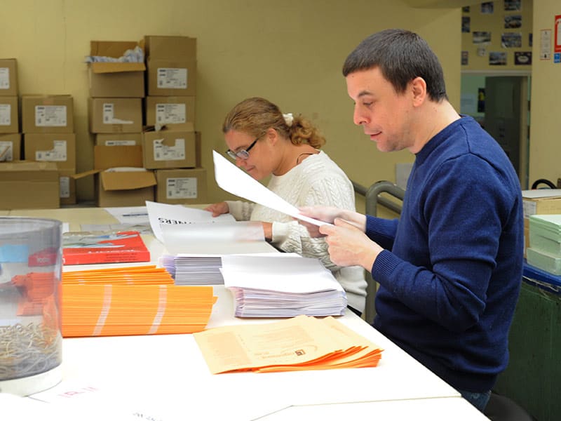 Photo de salariés en cours d'assemblage de documents papier